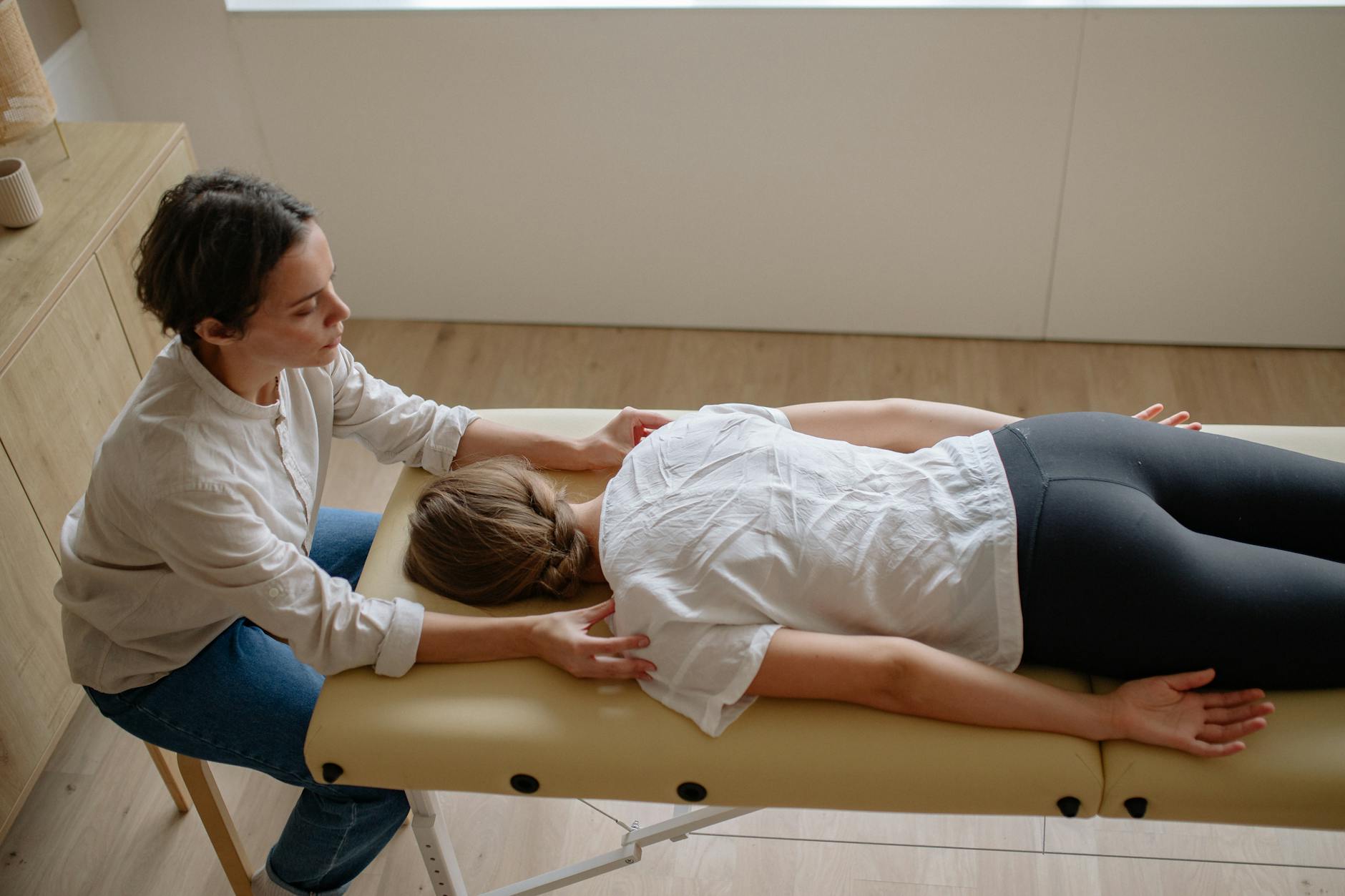 a woman in white shirt lying face down on the bed